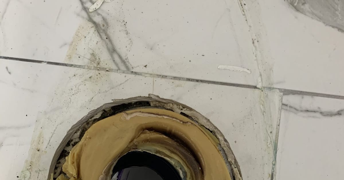 Toilet flange with old wax ring residue, toilet removed and ready for a new wax ring.