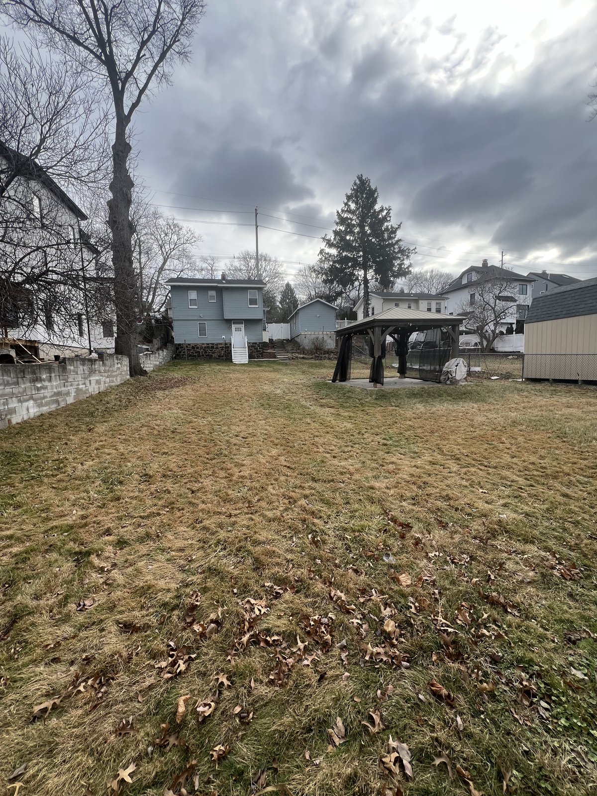 Backyard in winter before I started — gazebo, retaining wall, and the patio all needed a pass.
