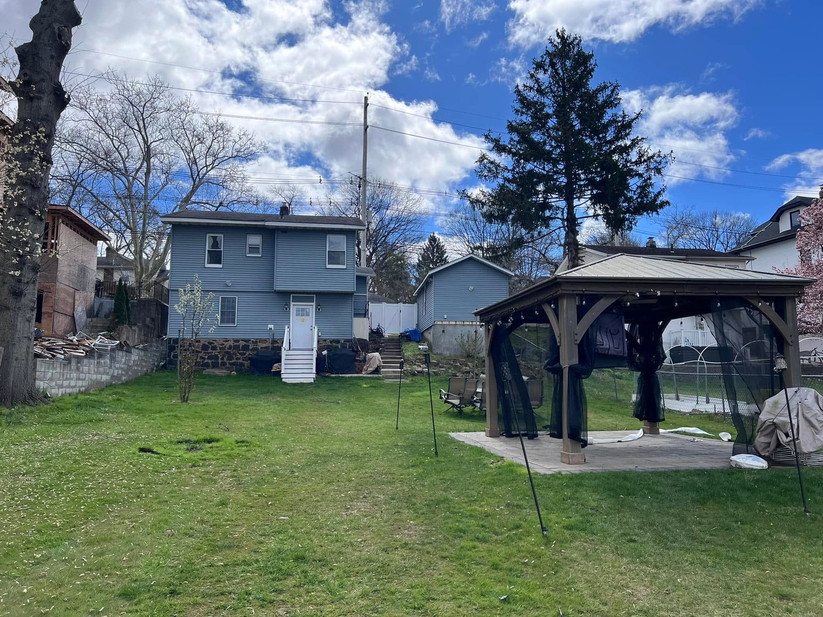 Backyard the day I closed — patio set, old gazebo, original shed. Plenty to work with.