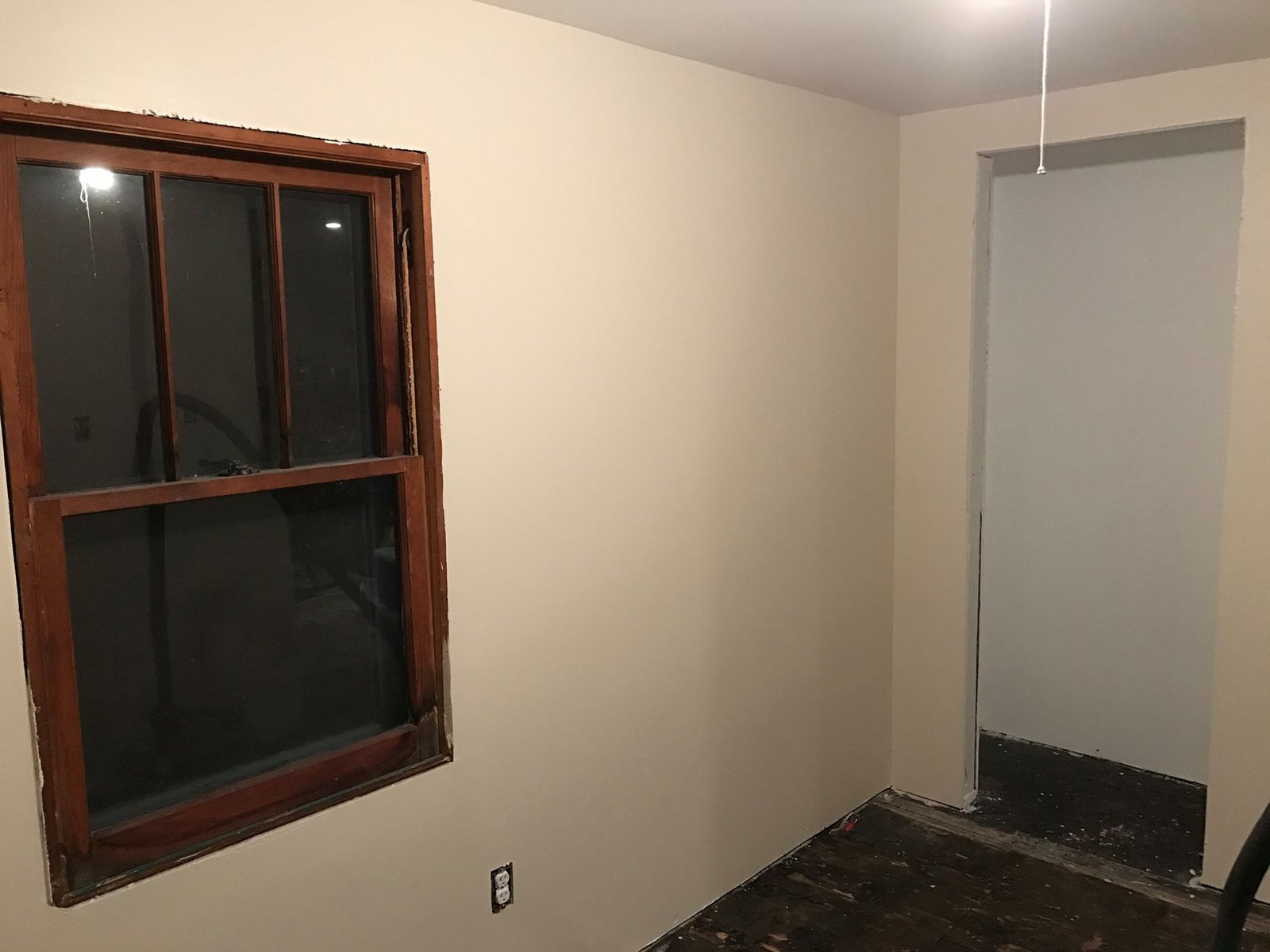 Bedroom with fresh paint and the original window trim. Subfloor still bare — flooring later.