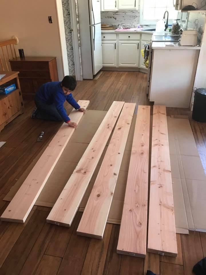 My son laying out the pine boards for the table top.