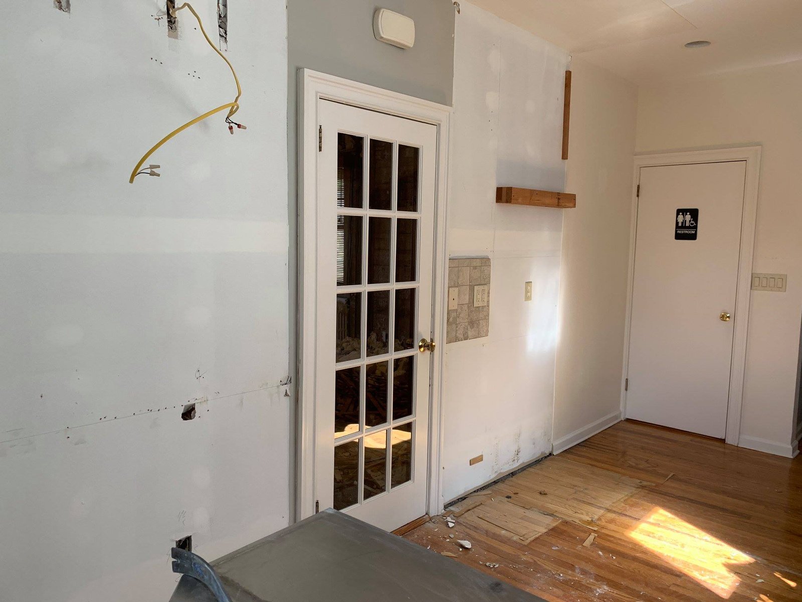 Cabinets out, wires capped, floor pulled — first room down to bones.