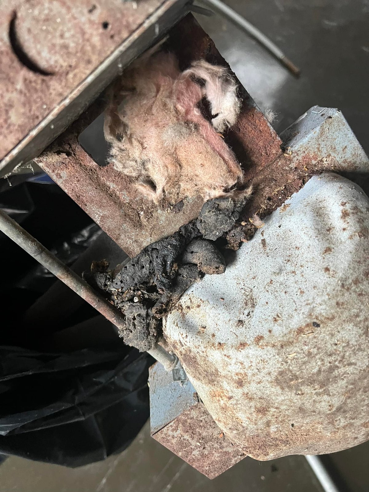 Original flue connection — corroded through, charred, insulation falling apart. Reason enough to redo the whole heating side.