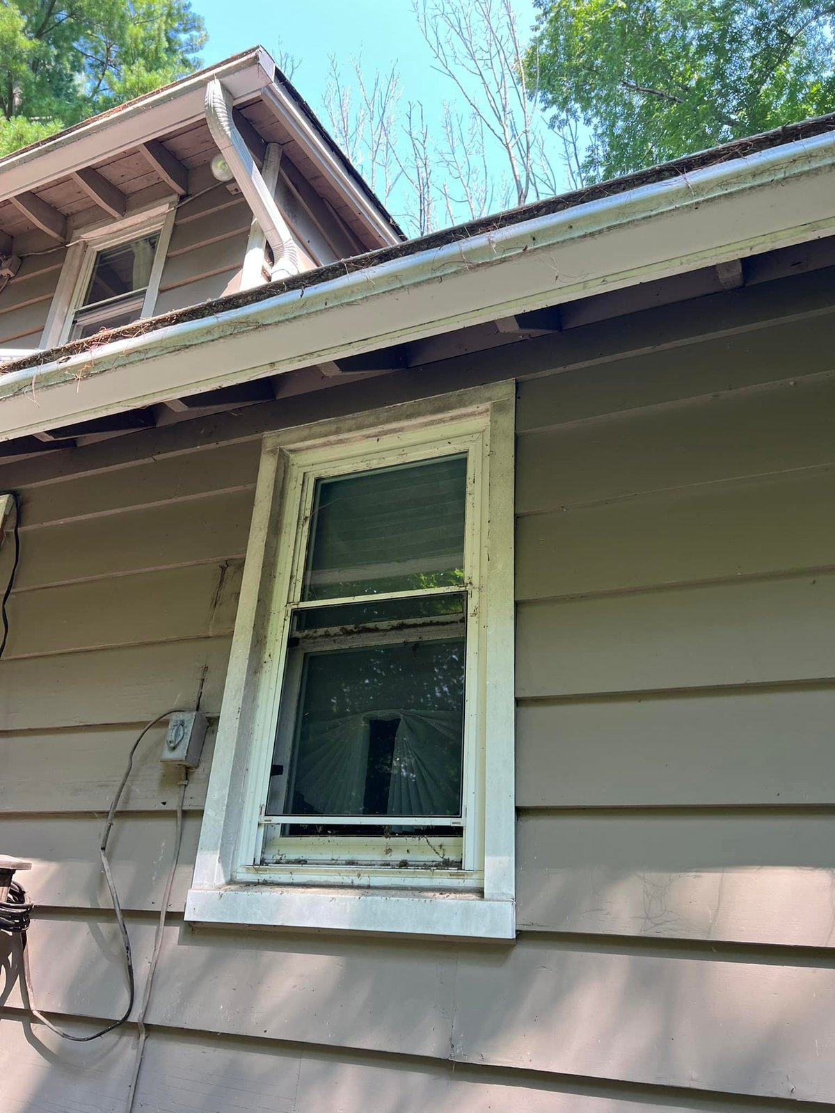 Original gutters were stuffed solid with debris — that was sending water straight into the fascia and back down the siding.