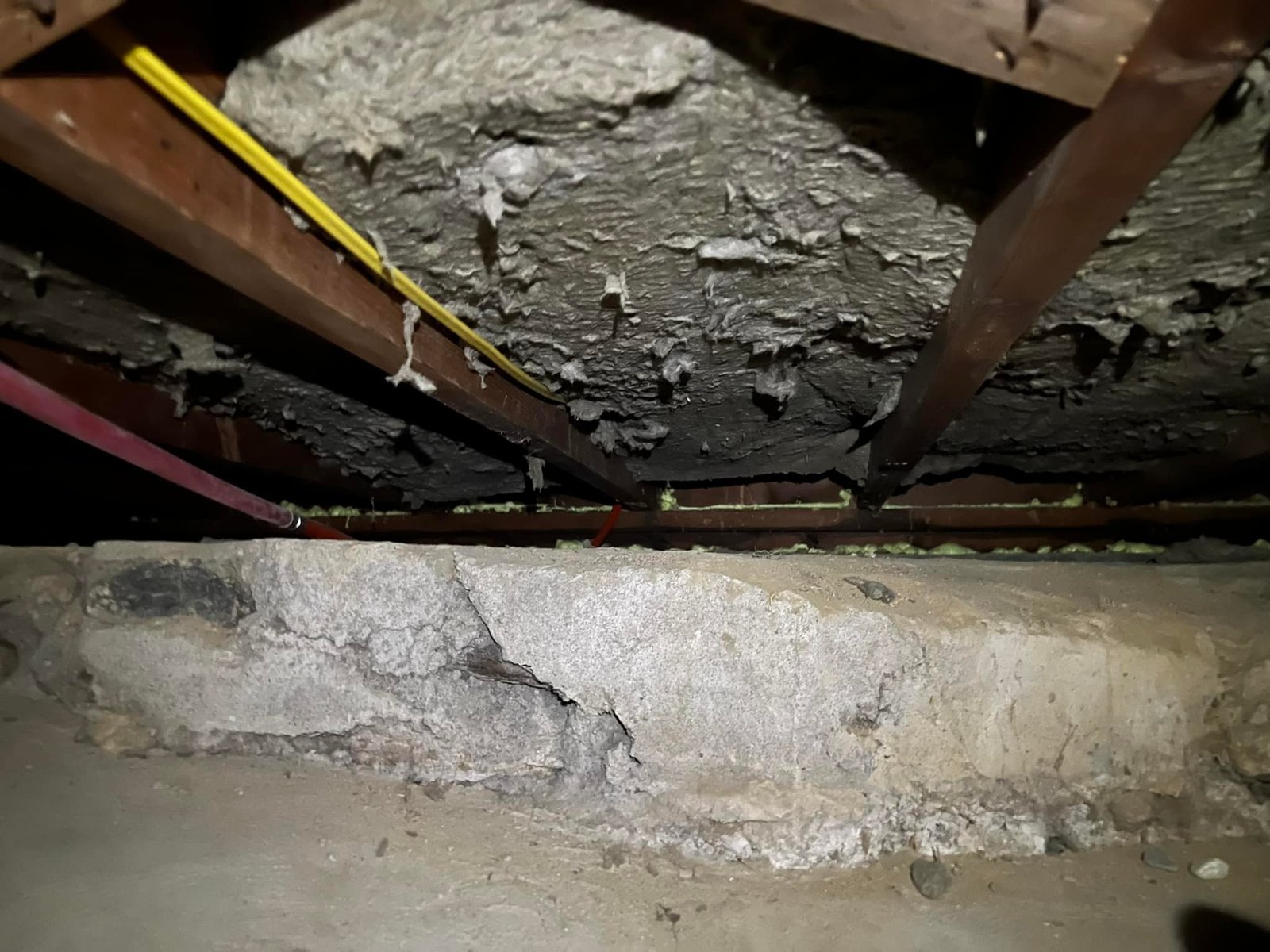 Before — crumbling sill, charred-looking subfloor, exposed wiring above. Worst part of the cottage.