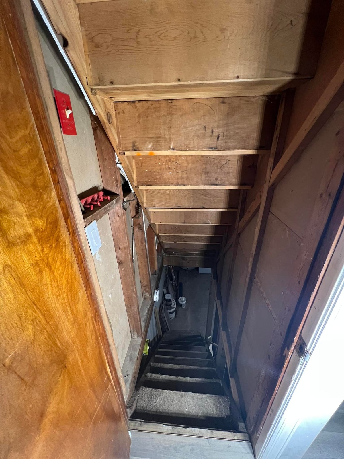 Looking down the open-tread stairs with the oil burner switch on the bare wall. Starting point.