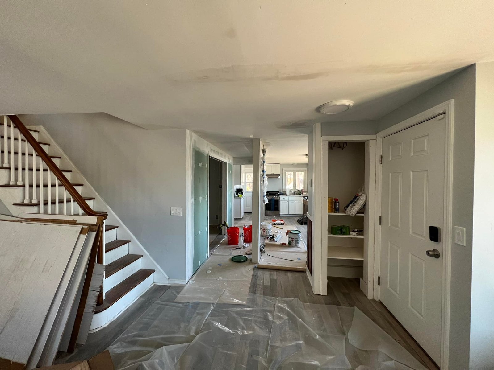 Entryway and stairs draped in plastic before the spray gun came out.