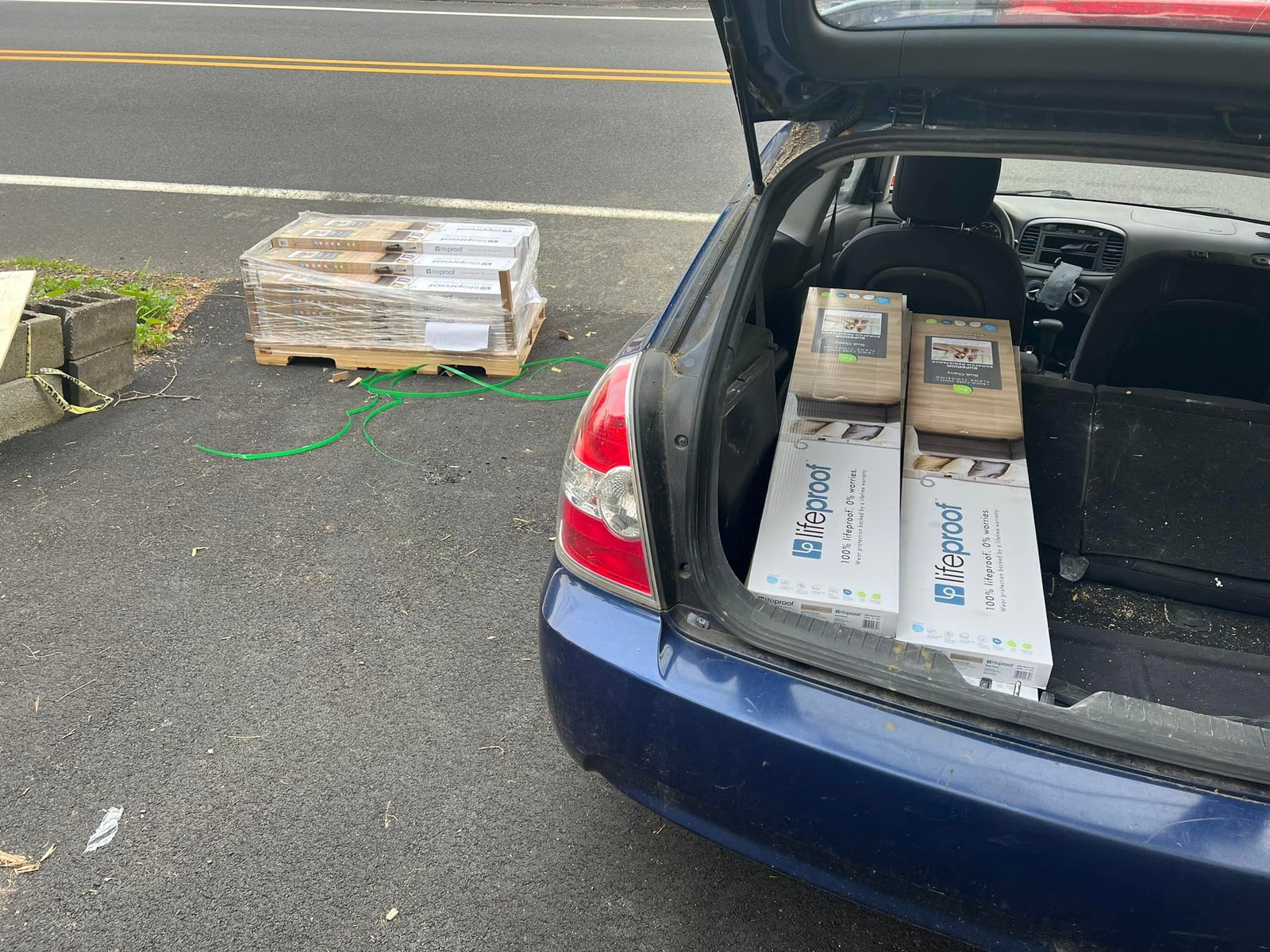 Loading flooring boxes into the trunk. I did most of the supply runs myself.
